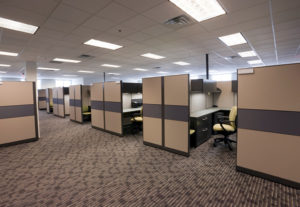 A room with many cubicles and chairs in it