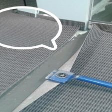 A pair of scissors cutting through the carpet.