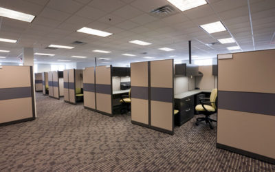 A room with many cubicles and chairs in it