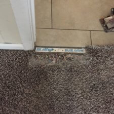 A carpet with a door sill that is in the middle of it.