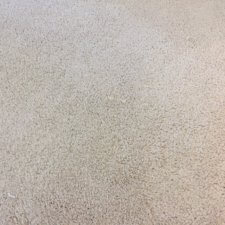 A white carpet with some brown spots on it